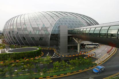 Vista exterior de la nueva terminal Jewel Changi, una cúpula toroidal de acero y cristal proyectada por Safdie Architects. A la derecha, la pasarela que conecta con las otras terminales del aeropuerto de Singapur.