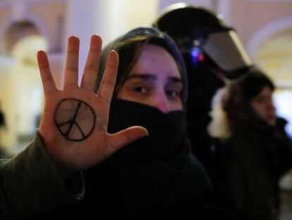 Con el símbolo de la paz pintado en su mano una manifestante es detenida en San Petersburgo (Rusia)