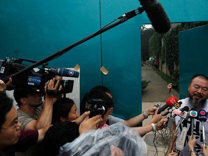 El artista chino Ai Weiwei habla con los periodistas que se han reunido hoy a las puertas de su casa en Pekín.