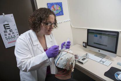 La psicóloga Sarah Laszlo coloca el casco para hacer electroencefalograma a uno de los individuos analizados.