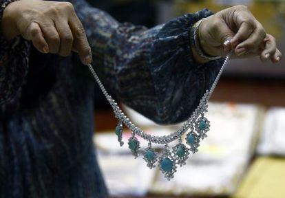 Una empleada de aduanas muestra un collar requisado hace 30 años a la ex primera dama filipina Imelda Marcos.