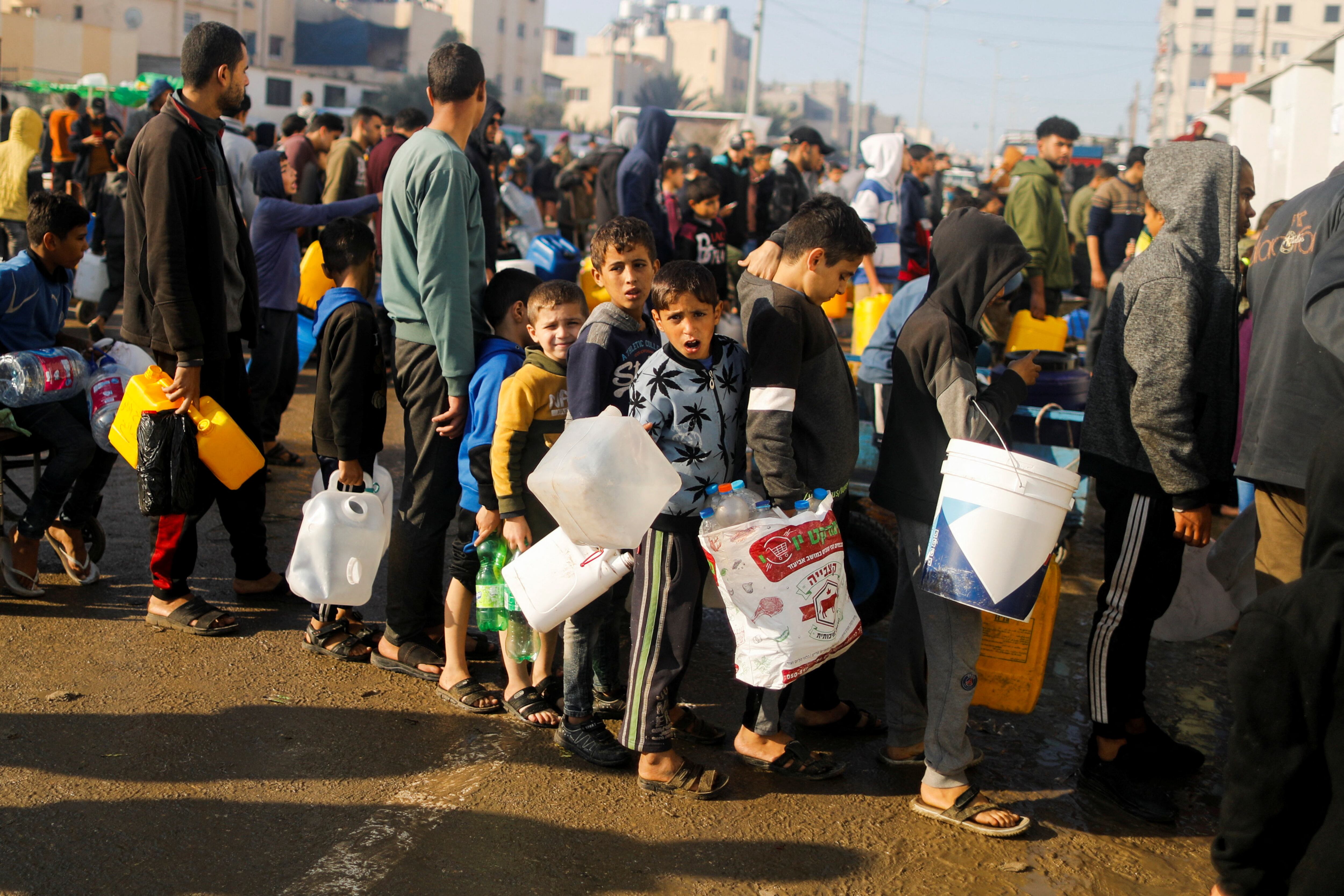 Muchos niños en una cola de distribución de agua en Rafah, al sur de la franja de Gaza, este jueves.