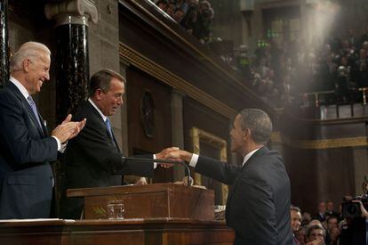 El presidente estadounidense saluda al presidente de la Cámara de Representantes, John Boehner al entregarle copia de su discurso, mientras el vicepresidente Joe Biden observa.
