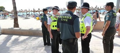 Membres de la Guàrdia Civil i 'bobbies' britànics patrullen per la platja de Magaluf.