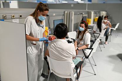 Dos enfermeras vacunan a un hombre en el Hospital Isabel Zendal de Madrid, en junio.