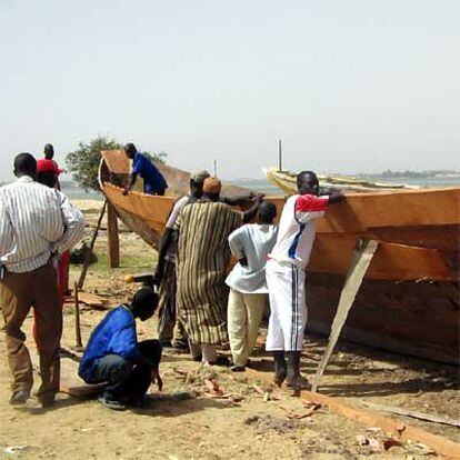 Carpinteros de Saint Louis, al norte de Senegal, reparan un cayuco para ser utilizado en la aventura de la emigración.