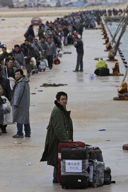 Ciudadanos de varias nacionalidades esperan un barco en el puerto de Bengasi.