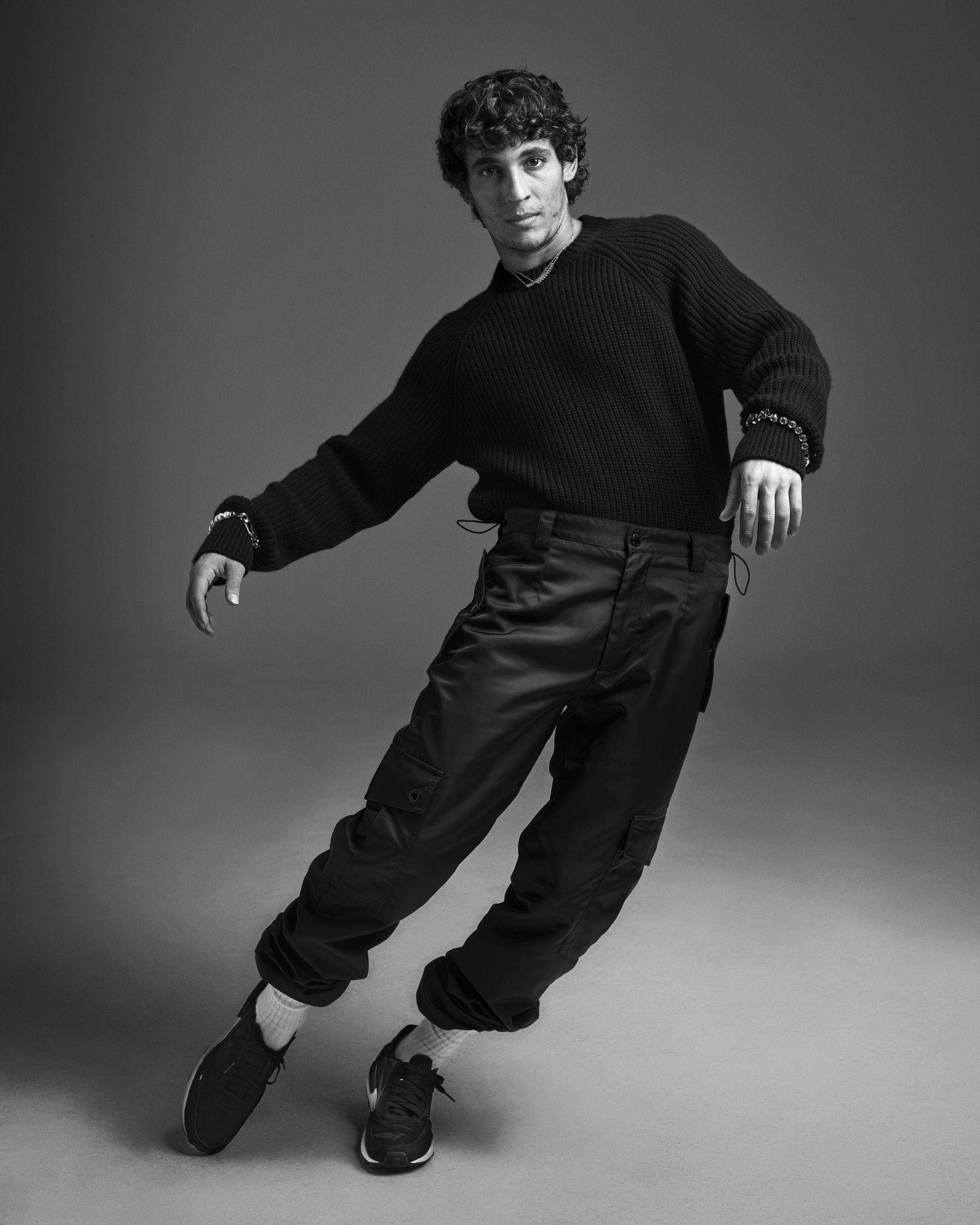 Miguel Herrán viste jersey y pantalón Dolce&Gabbana, zapatillas Nike y joyas Cartier.