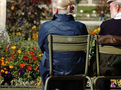 Dos personas mayores sentados en un parque de París.