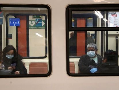 Usuarios protegidos con mascarillas en el interior de un vagón del Metro de Madrid.