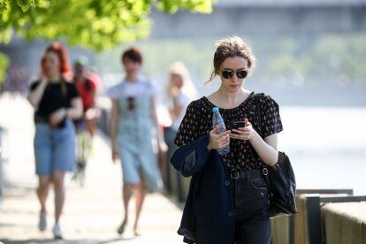 Una chica consulta su teléfono mientras pasea en Moscú.