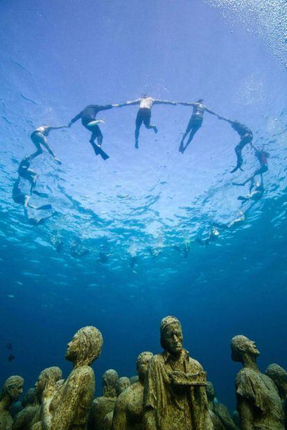 La instalación <i>Evolución silenciosa</i>, bajo el agua, realizada ayer en Cancún por Greenpeace y 350.org.