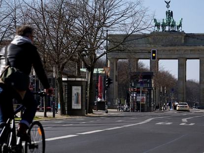 Un ciclista circula por el centro de Berlín junto a la puerta de Brandeburgo, el pasado martes.