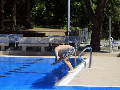 Un hombre se dispone a tirarse al agua de la piscina de Aluche.