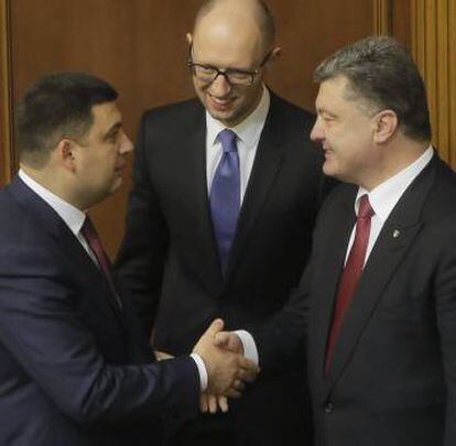 Groisman (izquierda), nuevo primer ministro, saluda al presidente Poroshenko, junto al jefe de Gobierno saliente, Arseni Yatseniuk.