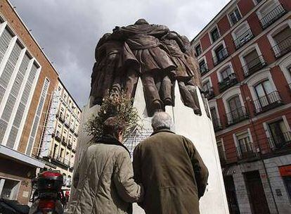 Dos personas leen la placa del monumento en memoria de los abogados muertos en la matanza de Atocha.
