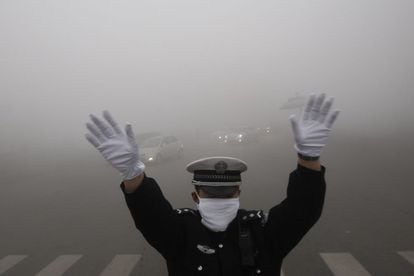 Un policía de tráfico se protege de la contaminación en la ciudad china de Harbin, 21 de octubre de 2013. Una densa niebla tóxica ha envuelto este lunes la ciudad china de Harbin, en el noroeste del país, por segundo día consecutivo.