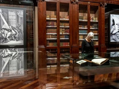 Una mujer mira un volumen de la Enciclopedia, entre una reproducción de una ilustración erótica del siglo XVIII y una imagen actual del fotógrafo Pedro Hernández, en la Biblioteca Histórica de la Universitat de València.