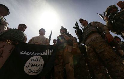Soldados iraquíes sostienen una bandera del grupo Estado Islámico durante las operaciones militares de recaptura de la provincia de Nínive.
