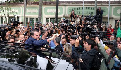 El candidato por el PSL, Jair Bolsonaro, rodeado de medios de comunicación, a su llegada al colegio electoral en Río de Janeiro.