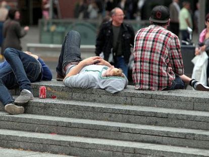 Uns joves descansen en una plaça de Barcelona.