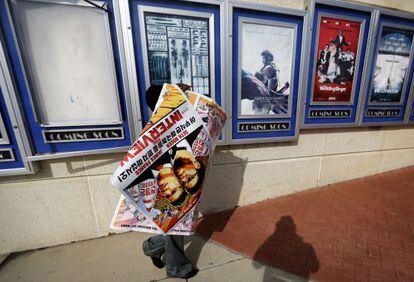 Un empleado retira los carteles de &#039;La entrevista&#039; de un cine de Atlanta.
