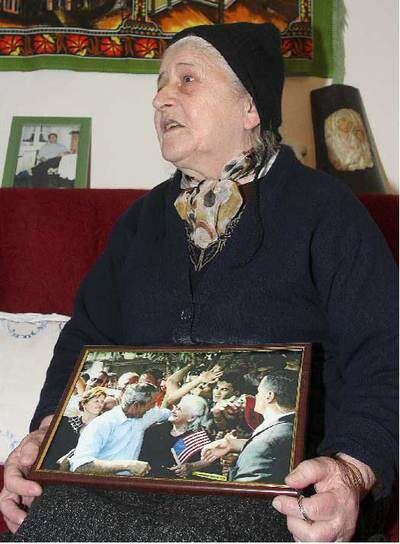 Una mujer albanesa muestra con orgullo la foto que se hizo junto al presidente Bush en 2007.