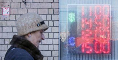 Mujer delante de una casa de cambio en Moscú. 