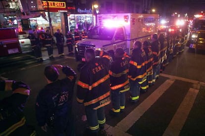 L'ambulància amb els agents assassinats passa davant dels bombers.