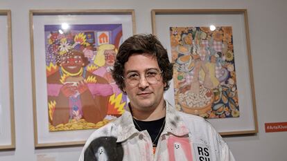 El artista Ricardo Cavolo posa frente a su obra, en la que Marsha P. Johnson y Sylvia Rivera disfrutan de comida rápida.