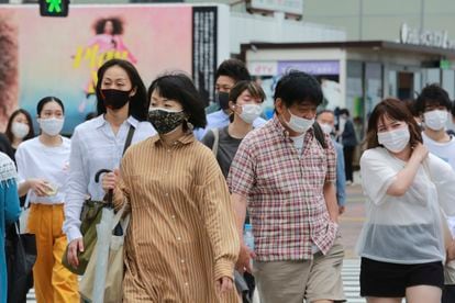Un grupo de personas con mascarilla para protegerse de la covid caminan este martes por una calle de Tokio ç