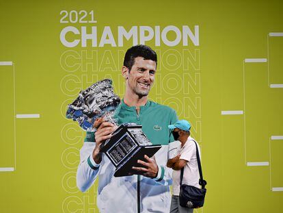 Un aficionado pasa por delante de la imagen de Djokovic en el primer día del Open de Australia en Melbourne.