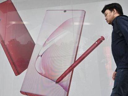 Un hombre pasea junto a un anuncio del Galaxy Note 10 5G.