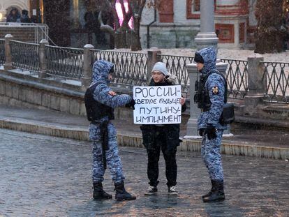 Dos agentes detienen a un manifestante con una pancarta que dice "Futuro brillante para Rusia, Impeachment para Putin", en la Plaza Roja de Moscú, el 15 de noviembre de 2022.