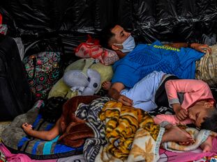 Migrantes venezolanos que esperan regresar a su país afuera de una terminal de buses en Medellín, Colombia.