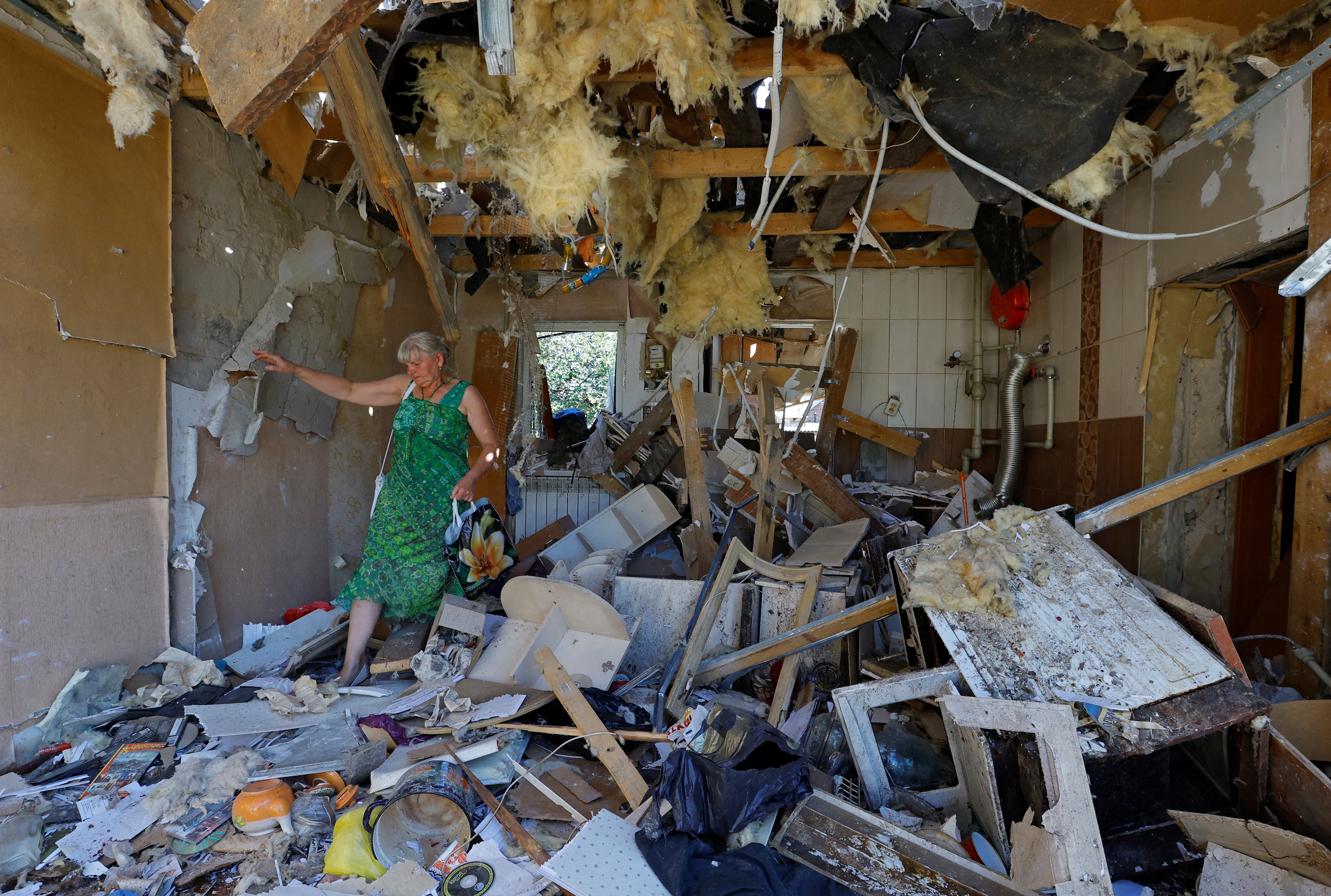 Una mujer mira las ruinas de su casa, destruida por un bombardeo ucranio, en la ciudad ocupada de Donetsk.