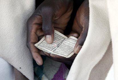 Detalle del Corán que está leyendo un inmigrante durante la oración a la salida del sol en el malecón del cruce fronterizo de San Ludovic, entre Italia y Francia.