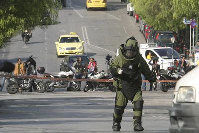 Un policía especialista en explosivos se acerca a detonar un paquete sospechoso, ayer en Atenas.