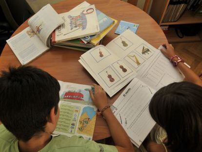 Alumnos en clase consultando sus libros de texto.