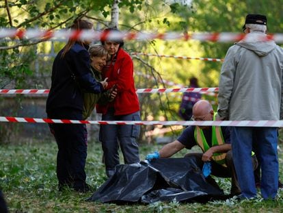 Una mujer llora cerca del cadáver de su hija, muerta en el ataque ruso contra Kiev de este jueves.