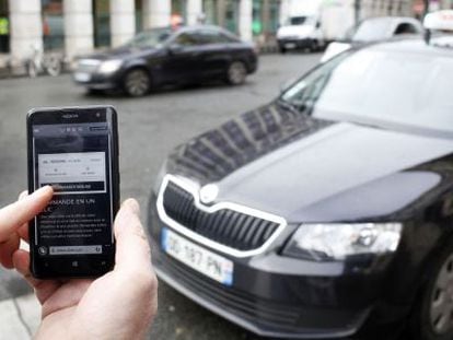 Un usuari utilitza el mòbil per reservar un cotxe d'Uber.