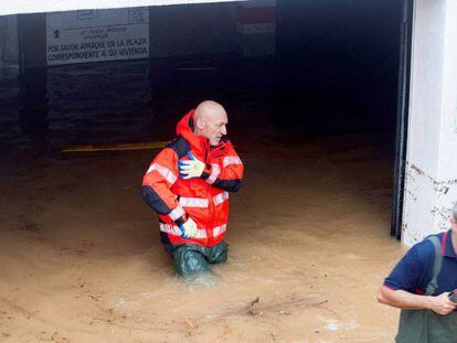 Dos bomberos, en uno de los garajes inundados en Alcoceber (Castellón).