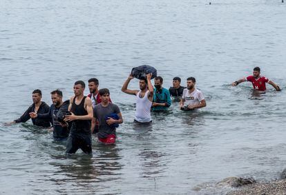 Un grupo de inmigrantes procedentes de Marruecos salen del agua tras cruzar a nado la frontera. El Ministerio del Interior ha informado este martes a media tarde que ha tramitado ya la devolución de unos 4.000 inmigrantes, la mitad de los cerca de 8.000 que han accedido a Ceuta de forma irregular desde ayer. Además, ha habilitado un sistema de gestión de 24 horas para agilizar estos trámites y un nuevo aumento de efectivos policiales en la zona.