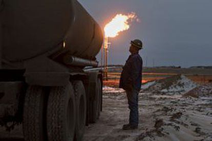 Un trabajador controla un camión durante las operaciones de carga en un pozo petrolífero en Montana (EE UU).