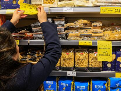 Una empleada de un supermercado colocando los precios de alimentos con el IVA rebajado.