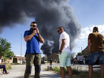 Vecinos de la localidad Chiloeches (Guadalajara) observan el incendio declarado en una planta de reciclaje de productos industriales.
