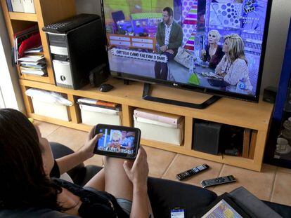 Una mujer ve la televisi&oacute;n en su casa.