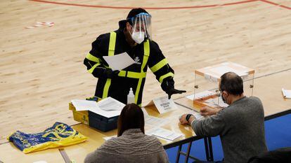 Un  cartero entrega el voto por correo en una mesa durante las elecciones catalanas del 14 de febrero.