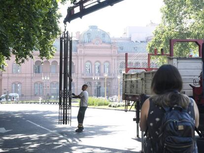 Un operario retira este lunes el último tramo que quedaba en pie de la reja que dividía la Plaza de Mayo. En vídeo, Mauricio Macri, el presidente de la desilusión.