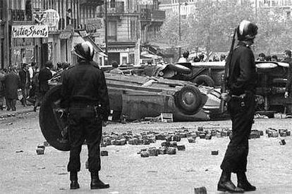 Antidisturbios vigilan ante una barricada en París en mayo de 1968.